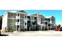 Apartment building with light green exterior, balconies, and ample parking at 35 Delray Dr. # 1-E, Murrells Inlet, SC 29576
