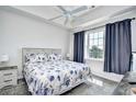 Bright bedroom with a ceiling fan, plush carpet, and a large window with blue curtains at 5801 Oyster Catcher Dr. # 434, North Myrtle Beach, SC 29582