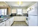 Bright kitchen featuring white cabinetry, granite countertops, stainless steel appliances, and tiled floors at 5801 Oyster Catcher Dr. # 434, North Myrtle Beach, SC 29582