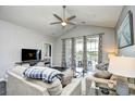 Cozy living room with vaulted ceiling, ceiling fan, modern furniture, and sliding glass doors to a balcony at 5801 Oyster Catcher Dr. # 434, North Myrtle Beach, SC 29582