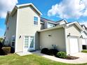 Rear exterior of home with a garage and a sliding glass door to the manicured lawn at 516 Papyrus Circle # 516, Little River, SC 29566