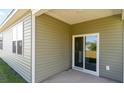 Covered back porch with a sliding glass door and a window; great for outdoor seating and privacy at 318 Cheerful Way, Little River, SC 29566