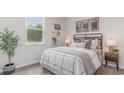 Cozy bedroom featuring a large window for natural light and a stylish bed with decorative pillows and artwork at 318 Cheerful Way, Little River, SC 29566