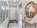 Inviting entryway with wood-look floors, decorative mirror, console table and neutral wall paint at 318 Cheerful Way, Little River, SC 29566