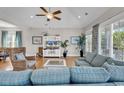 Bright living room boasts hardwood floors, large windows, and stylish, neutral-toned decor at 4989 Salt Creek Ct., North Myrtle Beach, SC 29582