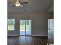 Bright living room featuring hardwood floors and sliding glass doors to the backyard at 2275 King Farm Rd., Aynor, SC 29511