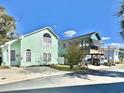 Exterior view of two homes, one a two-story light green design and the other an elevated blue, with ample parking space at 829 9Th Ave. S, North Myrtle Beach, SC 29582