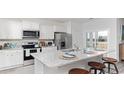 Modern eat-in kitchen featuring white cabinets, stainless appliances, and granite countertops with bar seating at 559 Duvall St., Longs, SC 29568