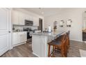 Bright kitchen with a granite-topped island, stainless steel appliances, white cabinets, and seating for casual dining at 573 Duvall St., Longs, SC 29568