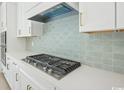 Modern gas cooktop with white shaker cabinets and soft green tile backsplash at 1035 Milford Way, Myrtle Beach, SC 29588