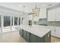Modern kitchen featuring a large island with pendant lighting and sliding glass doors to outside at 1035 Milford Way, Myrtle Beach, SC 29588