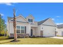 Two-story house with gray shutters, brick accents, and a two-car garage at 371 Lifestyle Court, Surfside Beach, SC 29575