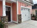 A view of the house address number and garage, with stone accents, and modern exterior lighting at 3131 Tiger Tail Rd., Conway, SC 29526