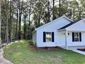 Exterior view of a charming house with a well-maintained lawn surrounded by lush trees at 74 Greentown Rd., Georgetown, SC 29440