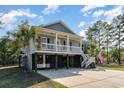 Charming elevated home with gray siding, white railings, and ample parking space underneath at 100 Lure Ct., Conway, SC 29526