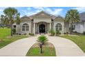 Charming home with a circular driveway, lush tropical landscaping, and manicured lawn at 202 Ave. Of The Palms, Myrtle Beach, SC 29579