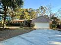 Charming brick home with a large driveway and mature landscaping, creating a welcoming curb appeal at 902 N 11Th Ave. N, North Myrtle Beach, SC 29582