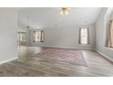 Spacious living room with wood-look flooring, ceiling fans, and large windows for plenty of natural light at 251 Galapagos Dr., Little River, SC 29566