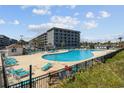 Outdoor pool area with many lounge chairs and a view of the condo building at 5905 S Kings Hwy. # 231, Myrtle Beach, SC 29577