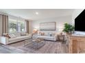 Bright living room boasts neutral colors, stylish furniture, and large windows at 560 Duvall St., Longs, SC 29568