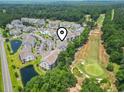 Scenic aerial view of condos nestled alongside lush greenery, a golf course, and serene pond at 5810 Longwood Dr. # 14-304, Murrells Inlet, SC 29576