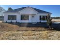 A bright home featuring black framed windows and doors, white siding, complemented by a new landscaped yard at 107 Deans Ct., Green Sea, SC 29545