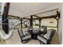 Covered patio with seating, a hammock, and a grill, perfect for relaxing and entertaining outdoors at 6001 - N14 S Kings Hwy., Myrtle Beach, SC 29575