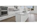 Modern kitchen with white cabinets, stainless steel appliances, and a beautiful countertop island at 512 9Th Ave. S, North Myrtle Beach, SC 29582