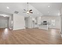 Bright and airy living room seamlessly flowing into the kitchen, complete with wood floors and neutral walls at 6025 Flossie Rd., Conway, SC 29527