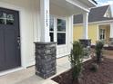Inviting front porch with stone-accented columns and freshly landscaped yard at 3125 Tiger Tail Rd., Conway, SC 29526