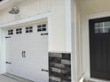 Attached garage with carriage-style doors and stone detailing at 3125 Tiger Tail Rd., Conway, SC 29526