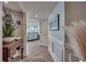 Hallway with tiled floor, wooden console table, and wall art leading to the living area at 9650 Shore Dr. # 1805, Myrtle Beach, SC 29572