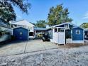 Charming blue home with white trim, features a covered patio, spacious driveway, and a convenient golf cart at 6001 - N21 S Kings Hwy., Myrtle Beach, SC 29575