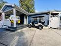 Cozy blue home with a covered patio, outdoor seating, and a convenient golf cart parked in the driveway at 6001 - N21 S Kings Hwy., Myrtle Beach, SC 29575