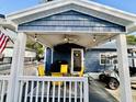 Covered outdoor patio with stylish lighting, ceiling fan, grill, and a comfortable seating area for relaxing at 6001 - N21 S Kings Hwy., Myrtle Beach, SC 29575
