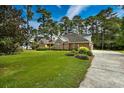 Beautiful brick home featuring an expansive green lawn and mature landscaping at 3517 Golf Ave., Little River, SC 29566