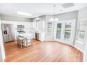 Bright kitchen with white cabinets, stainless steel appliances, an island with seating, and wood-look floors at 629 Slash Pine Ct., Myrtle Beach, SC 29579