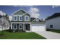 Two-story house with green siding, a two-car garage, and landscaping at 203 Portofino Dr., Myrtle Beach, SC 29579