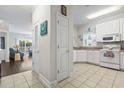 Bright kitchen featuring white cabinetry, a window over the sink, and tiled flooring, open to living area at 1100 Commons Blvd. # 104, Myrtle Beach, SC 29572