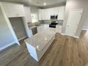 Bright kitchen featuring white cabinets, stainless steel appliances, granite countertops and island, and hardwood floors at 348 Jay St., Murrells Inlet, SC 29576