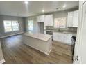 Bright kitchen featuring white cabinets, stainless steel appliances, granite countertops and island, and hardwood floors at 348 Jay St., Murrells Inlet, SC 29576