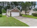 Home's brick-accented two-car garage and driveway nestled among green lawns and shade trees at 376 Mckendree Ln., Myrtle Beach, SC 29579