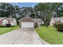 Beautiful exterior view of home with manicured lawn, brick accents, driveway, and large shade tree at 376 Mckendree Ln., Myrtle Beach, SC 29579