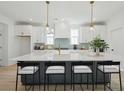 Bright, modern kitchen with a large island, seating, white cabinets, gold hardware, and stylish decor at 1099 Milford Way, Myrtle Beach, SC 29588