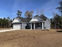 Inviting single-story home with blue siding, white trim, a two-car garage, and a neatly maintained front yard at 216 Palmetto Sand Loop, Conway, SC 29527