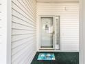 Charming condo entrance with decorative doormat, nautical-themed decor, and a white siding at 4430 Turtle Ln. # 2-C, Little River, SC 29566