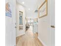 Bright hallway leading to the living area with beachy decorations, light wood flooring, and an open layout at 4430 Turtle Ln. # 2-C, Little River, SC 29566