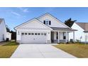 Two-story house with gray siding, light gray garage door, and a covered porch at 1613 Littleleaf Loop, North Myrtle Beach, SC 29582