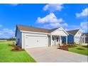 Angle shot of single-story home with attached garage and manicured front lawn on a clear day at 3046 Deerberry Place, Longs, SC 29568
