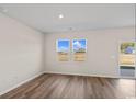 Well-lit living room featuring wood-look floors, light walls, and sliding glass door at 3046 Deerberry Place, Longs, SC 29568
